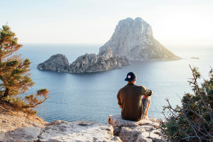 man takes a break from work looking at ocean